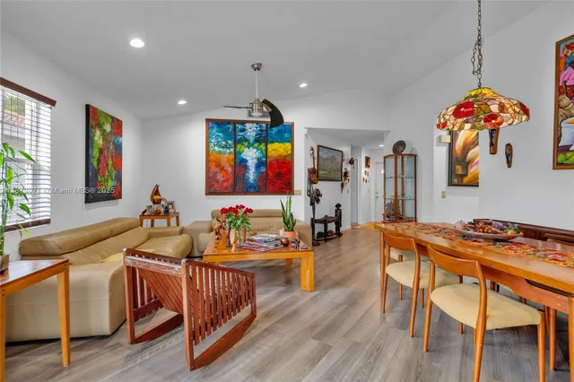 a living room with furniture kitchen and a large window