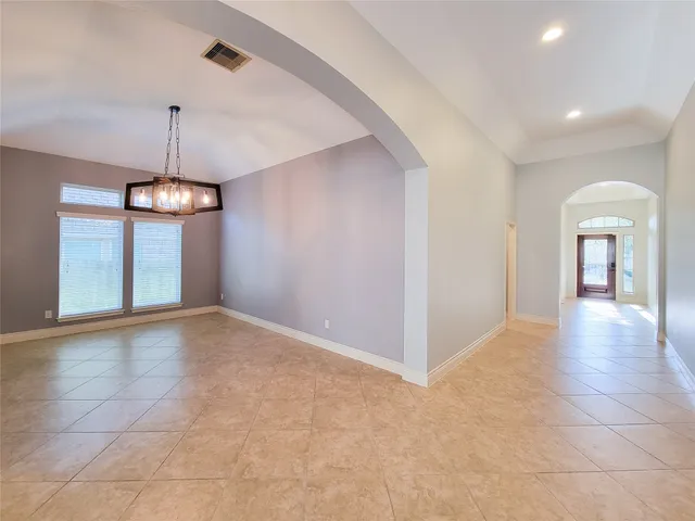 a view of a hallway with windows and chandelier