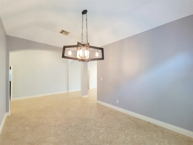 a view of a room with a ceiling fan and refrigerator