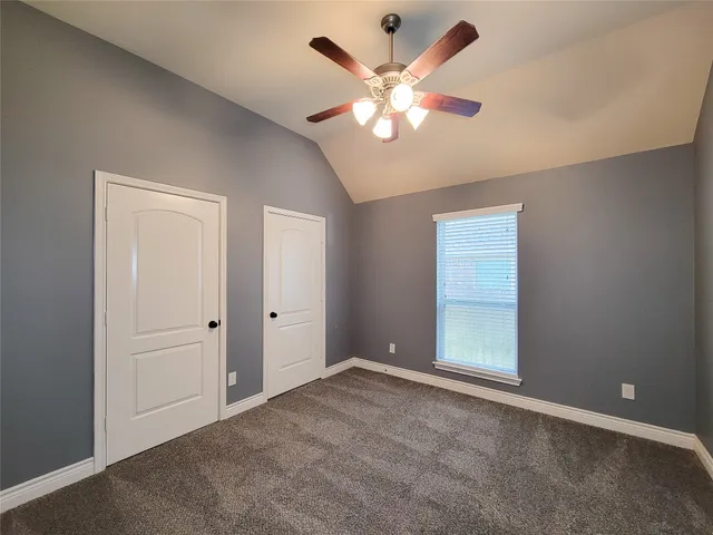 an empty room with chandelier fan