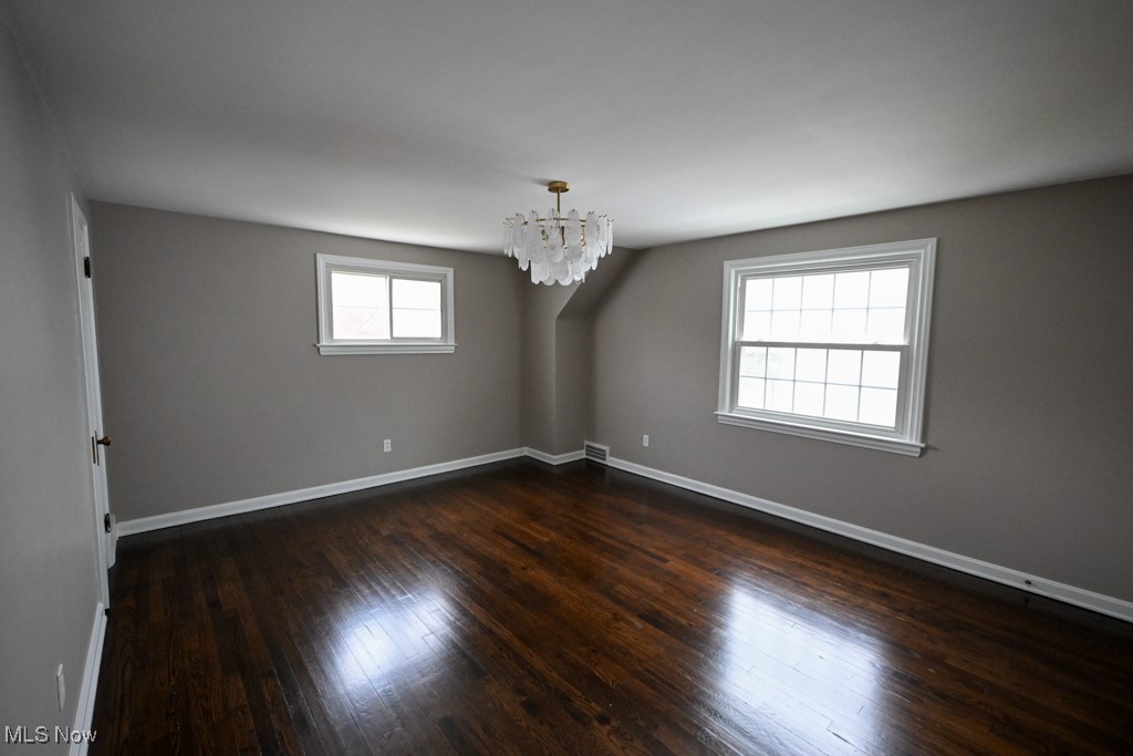 2284 Traymore Road Cleveland, OH 44118 - Photo 14 of 19 Unfurnished room with baseboards, a chandelier, and dark wood finished floors