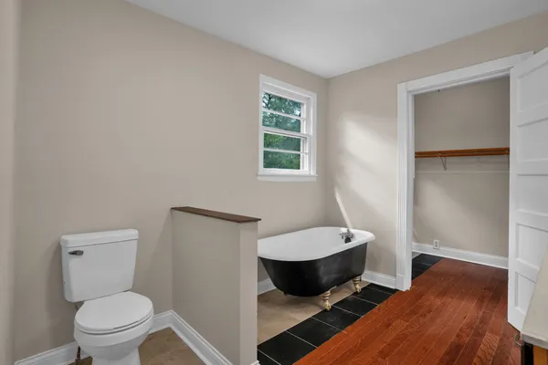 a bathroom with a granite countertop toilet a sink and a mirror