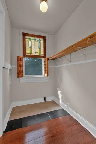 a view of empty room with wooden floor and fan