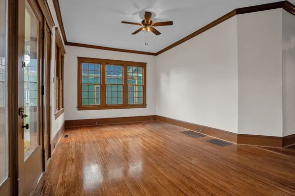 a view of a room with wooden floor and a ceiling fan