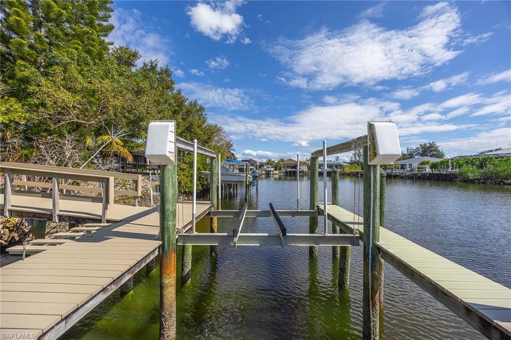 146 Windward Cay Naples, FL 34114 - Photo 32 of 33 a view of a lake with a deck and a patio