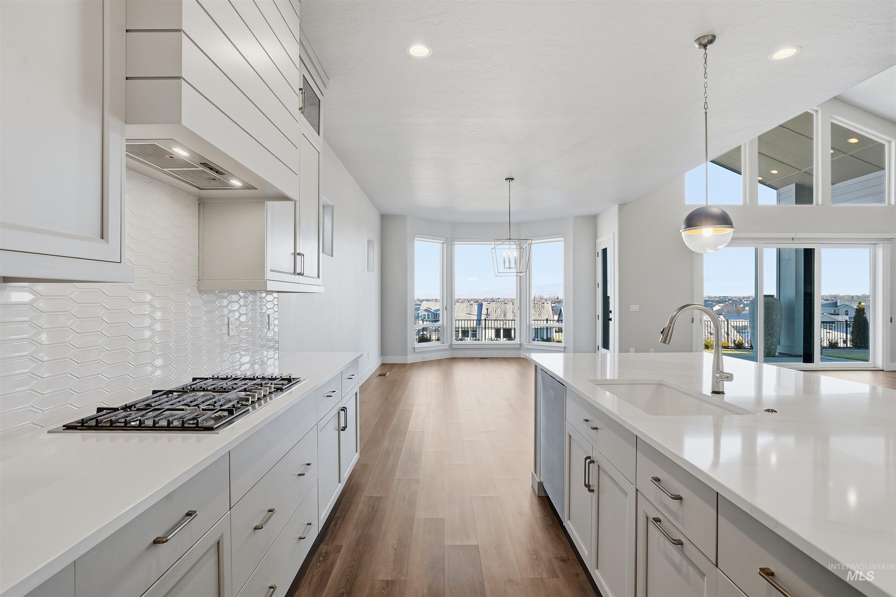 2976 East Parulo Drive Meridian, ID 83642 - Photo 14 of 40 Kitchen with dark wood finished floors, decorative light fixtures, recessed lighting, stainless steel appliances, and white cabinets