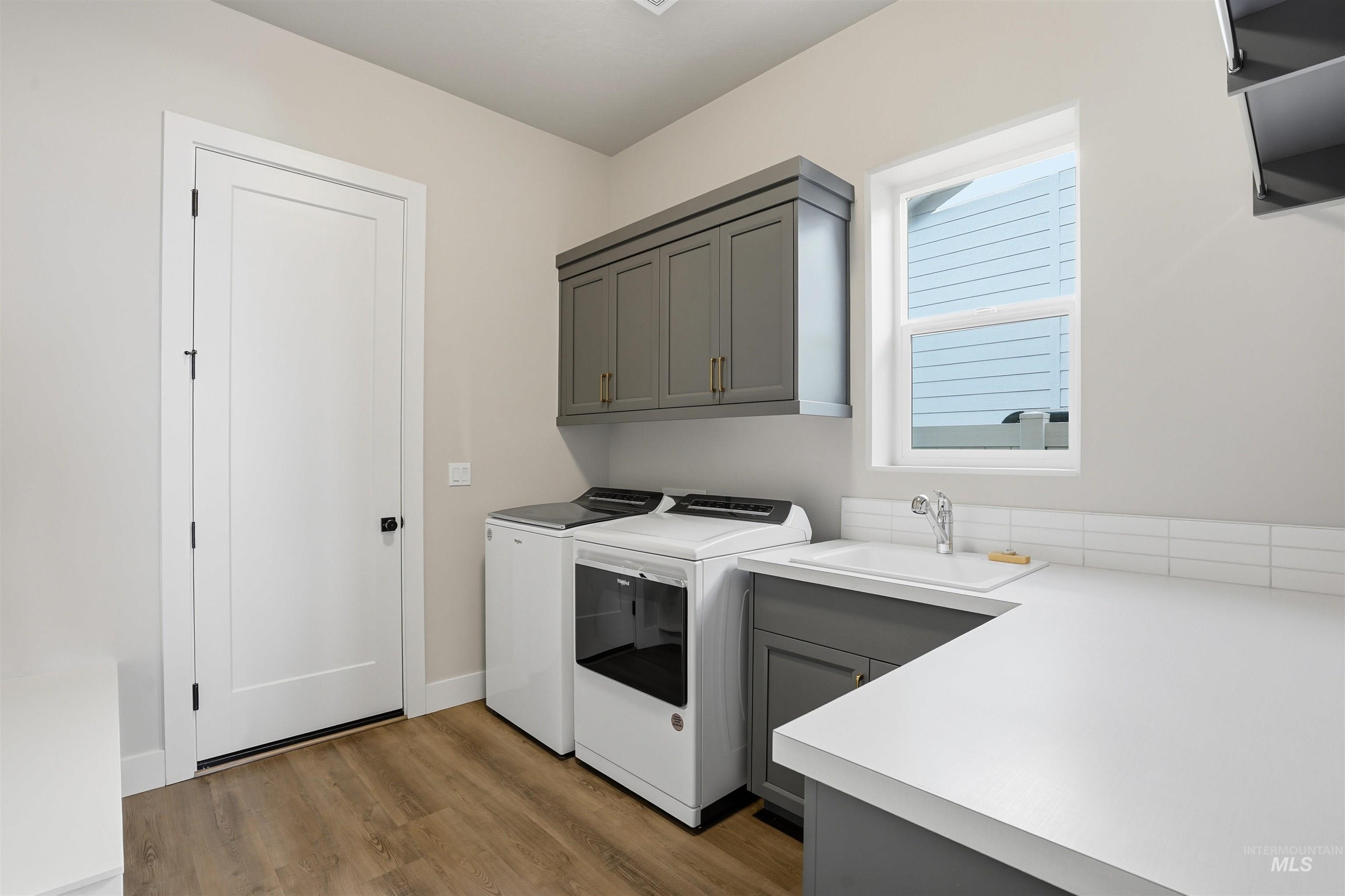 2976 East Parulo Drive Meridian, ID 83642 - Photo 16 of 40 Laundry area featuring washing machine and dryer, dark wood-style flooring, and cabinet space