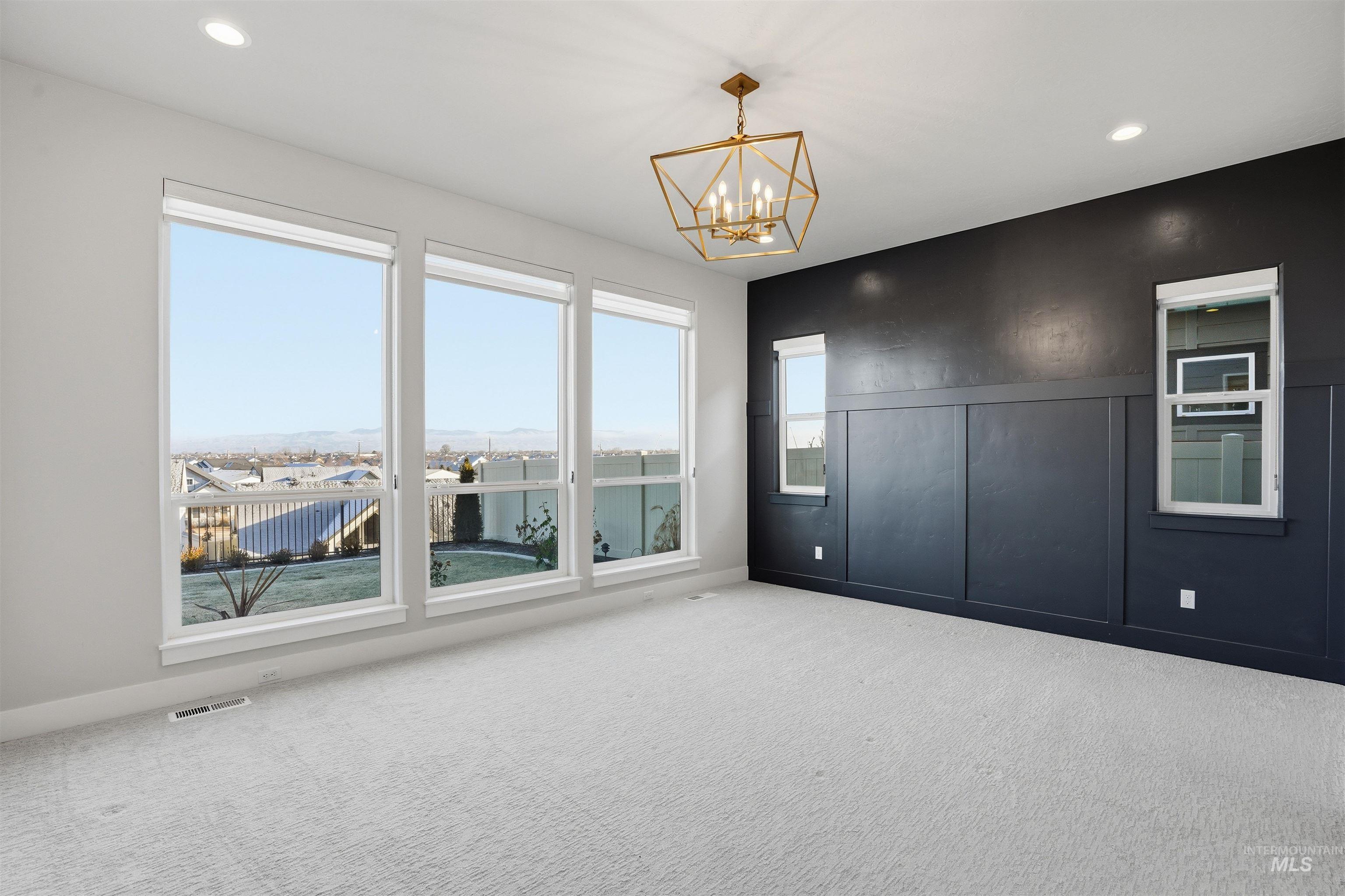 2976 East Parulo Drive Meridian, ID 83642 - Photo 18 of 40 Empty room featuring carpet, recessed lighting, a chandelier, and a decorative wall