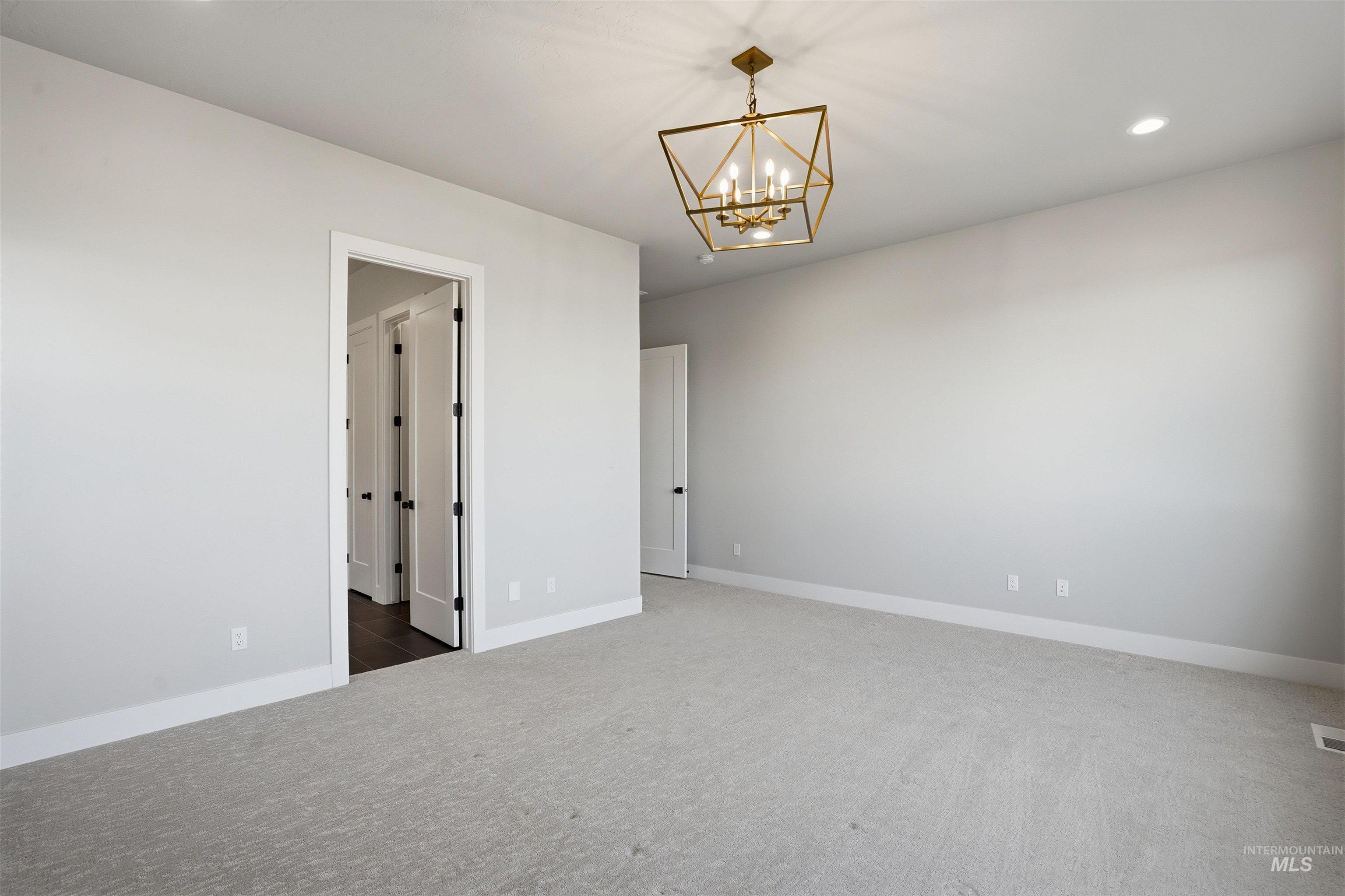 2976 East Parulo Drive Meridian, ID 83642 - Photo 19 of 40 Carpeted spare room with recessed lighting and a chandelier