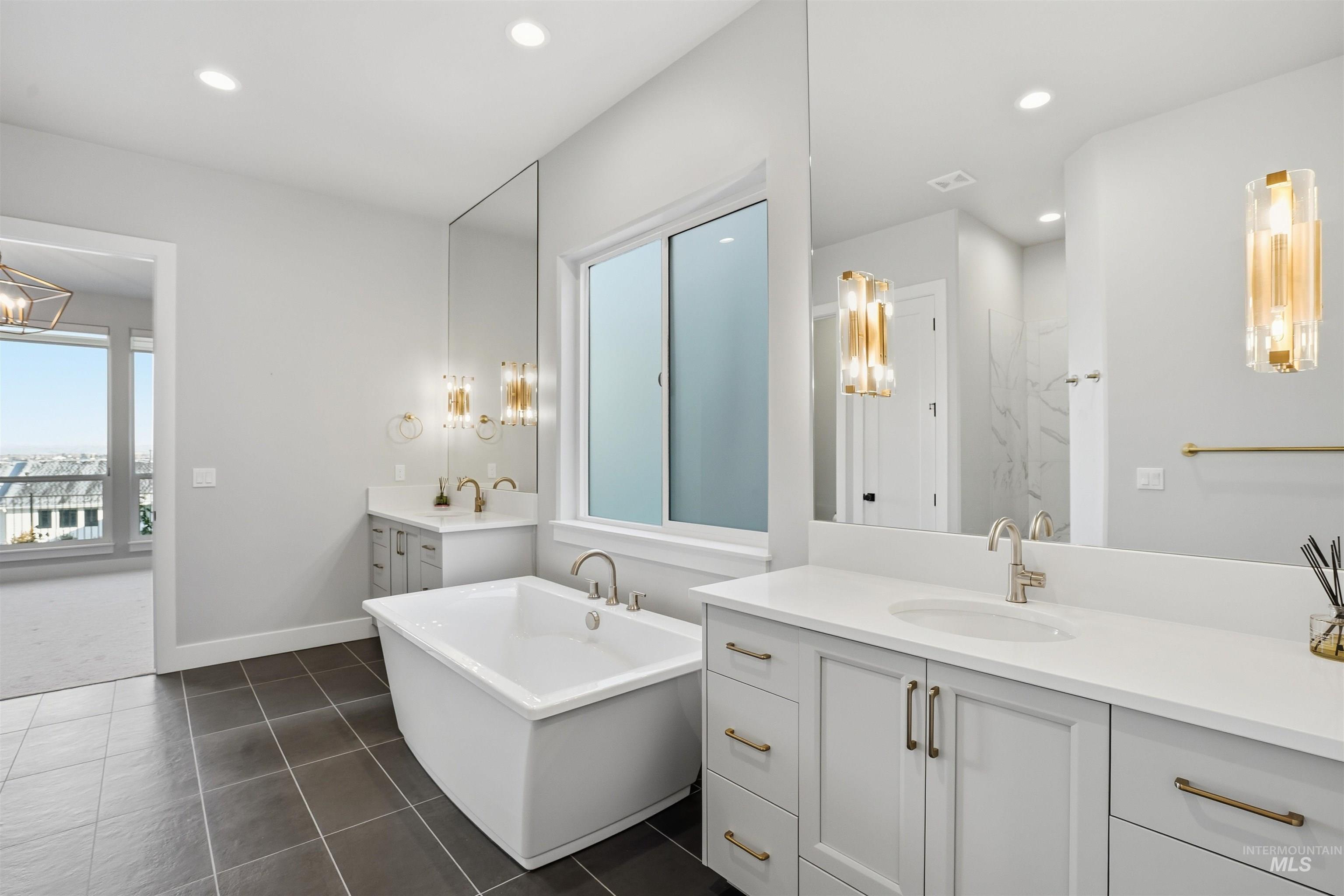 2976 East Parulo Drive Meridian, ID 83642 - Photo 21 of 40 Full bath featuring a freestanding bath, two vanities, recessed lighting, and dark tile patterned flooring