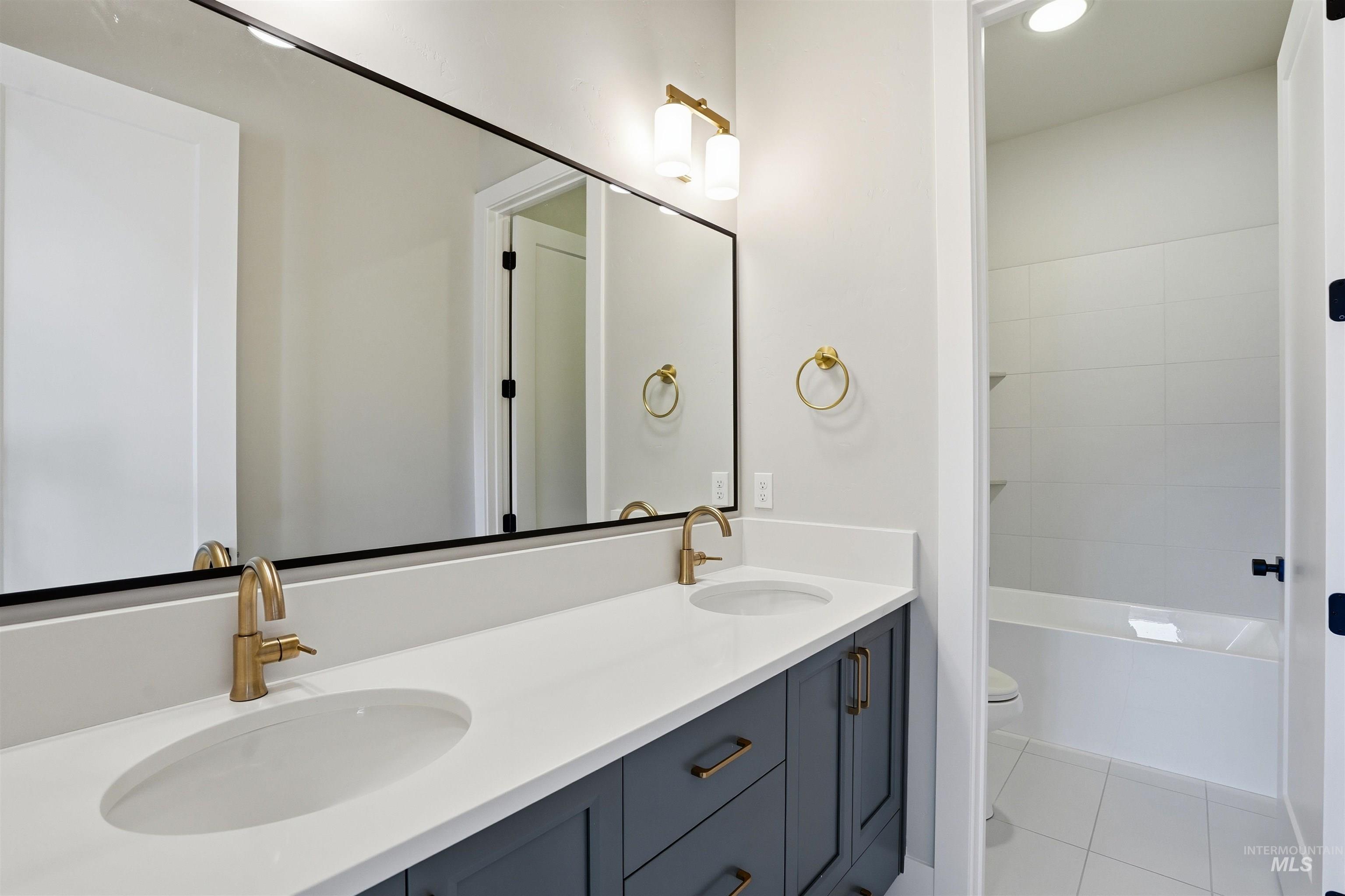 2976 East Parulo Drive Meridian, ID 83642 - Photo 25 of 40 Bathroom featuring double vanity, light tile patterned flooring, and bathing tub / shower combination