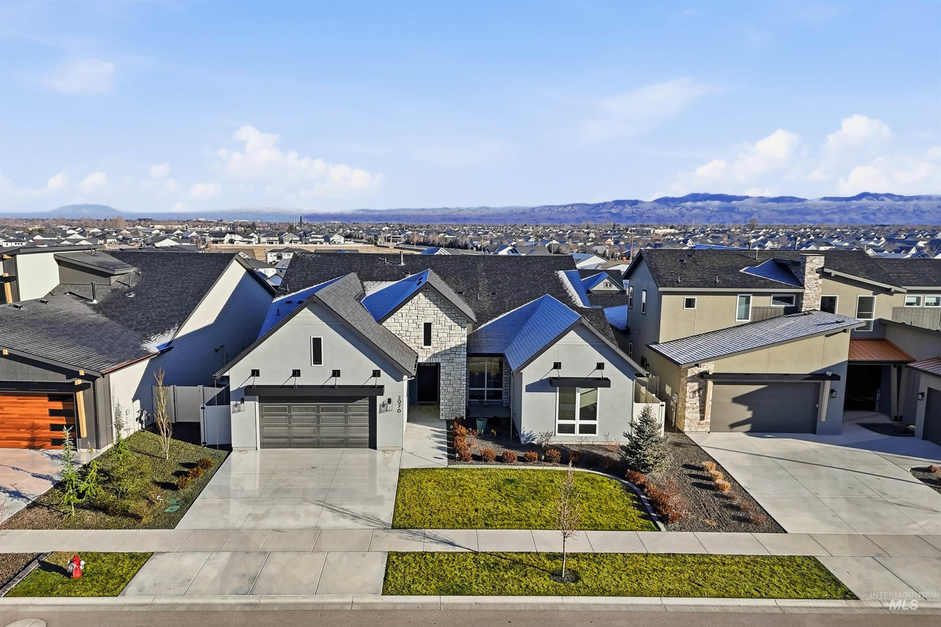 2976 East Parulo Drive Meridian, ID 83642 - Photo 3 of 40 View of front of property featuring a residential view, driveway, stone siding, and stucco siding