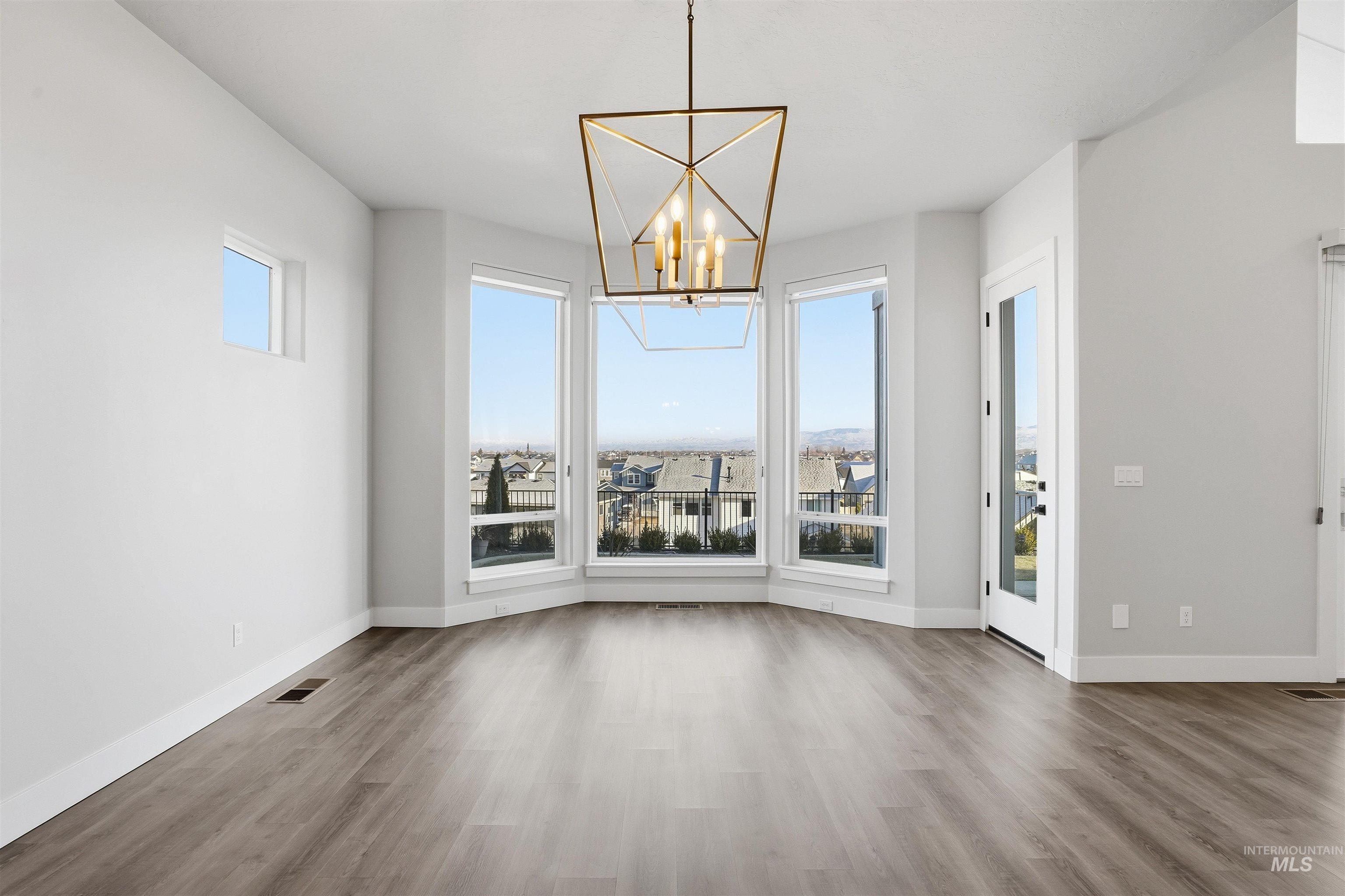 2976 East Parulo Drive Meridian, ID 83642 - Photo 9 of 40 Unfurnished dining area featuring a chandelier and wood finished floors