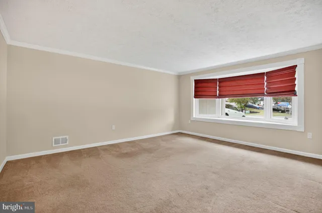 an empty room with windows and ceiling fan