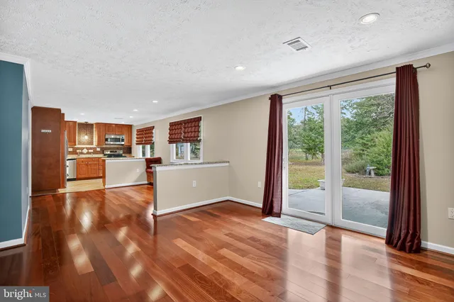 a view of a living room and kitchen with furniture wooden floor and window