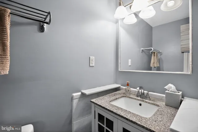 a bathroom with a granite countertop sink and a mirror