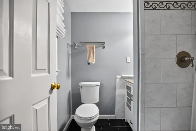 a white toilet sitting next to a bathroom sink and a shower