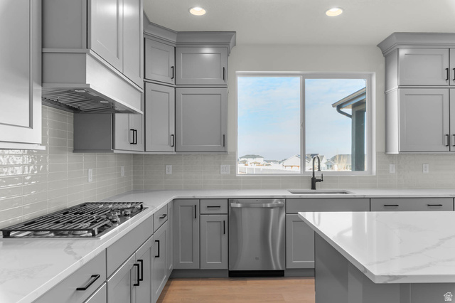 562 West Coyote Rdg Road Grantsville, UT 84029 - Photo 15 of 27 Contemporary kitchen featuring gray shaker-style cabinetry, white countertops, a built-in gas range with range hood, and a stainless steel dishwasher