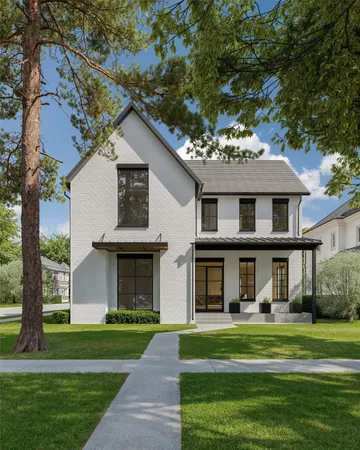 a front view of a house with a garden and trees