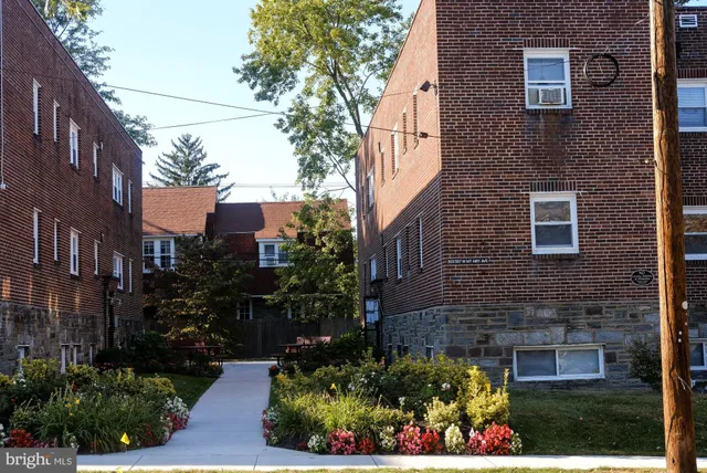 a view of a brick house with a yard and potted plants