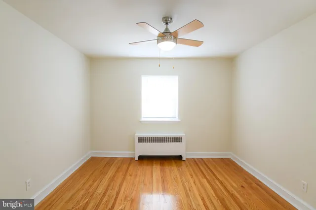 a view of room with window ceiling fan and hardwood floor