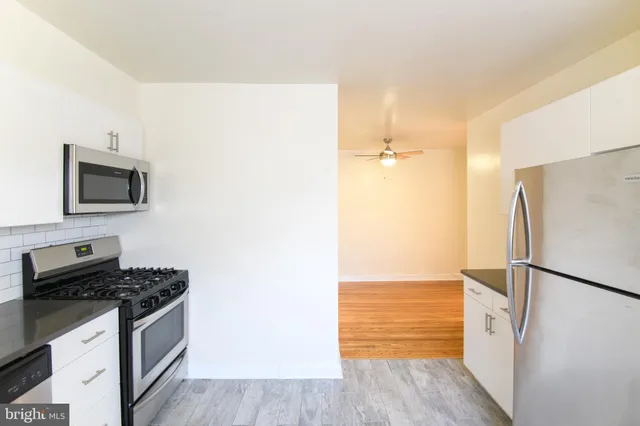 a kitchen with a refrigerator and a stove top oven