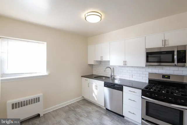 a kitchen with granite countertop a sink and a stove top oven