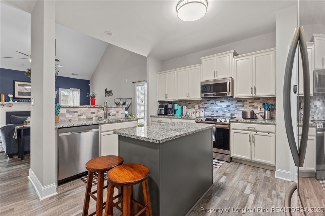 160 Huzzas Circle Cameron, NC 28326 - Photo 3 of 34 a kitchen with granite countertop a sink stove and refrigerator