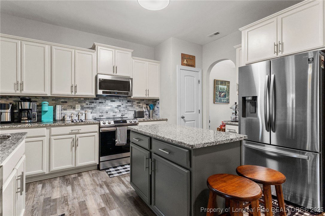 160 Huzzas Circle Cameron, NC 28326 - Photo 4 of 34 a kitchen with stainless steel appliances granite countertop a stove refrigerator sink and cabinets