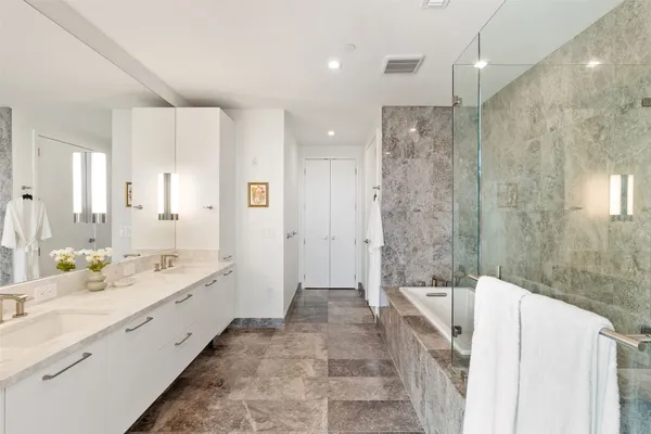 a bathroom with a bathtub shower and sink
