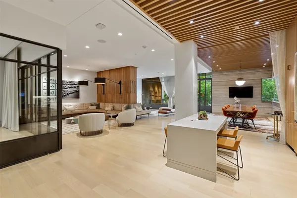 a living room with stainless steel appliances furniture a dining table and kitchen view
