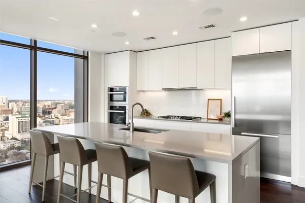 a kitchen with kitchen island a large window and cabinets
