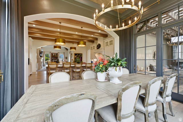71 Farm Road Midway, UT 84049 - Photo 15 of 92 Dining area featuring a large distressed wood-finish table, a gold-tone chandelier, and multiple paneled glass doors