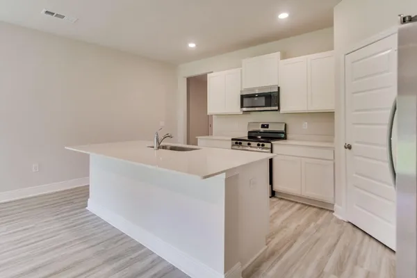 a kitchen with a sink a microwave a stove and refrigerator