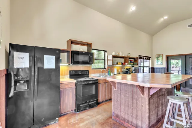 a kitchen with stainless steel appliances granite countertop a refrigerator and a stove top oven