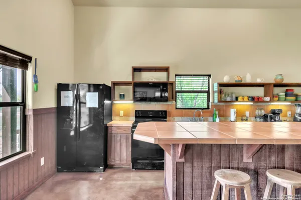 a kitchen with stainless steel appliances a table and chairs in it