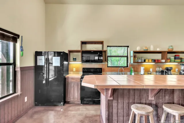 a kitchen with stainless steel appliances a table and chairs in it