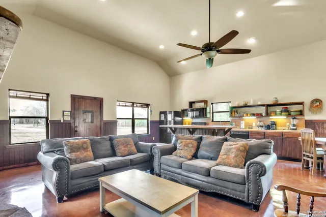 a living room with furniture a ceiling fan and a window