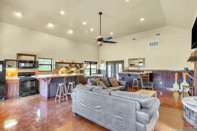 a living room with furniture a chandelier and a dining table