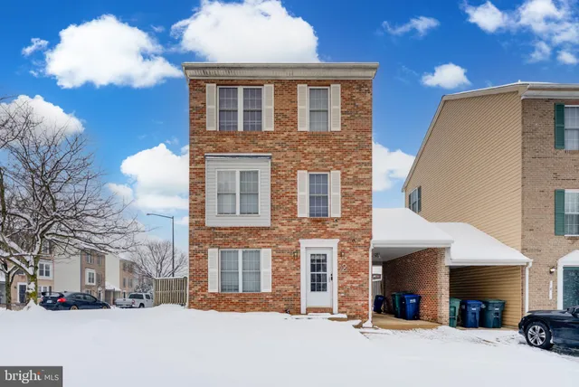 a front view of a building with lot of cars and trees