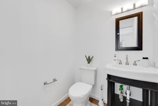a bathroom with a toilet a sink and mirror