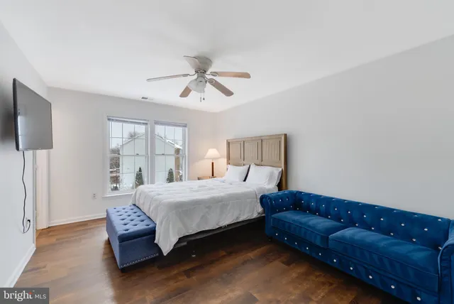 a bedroom with a bed couch and a window