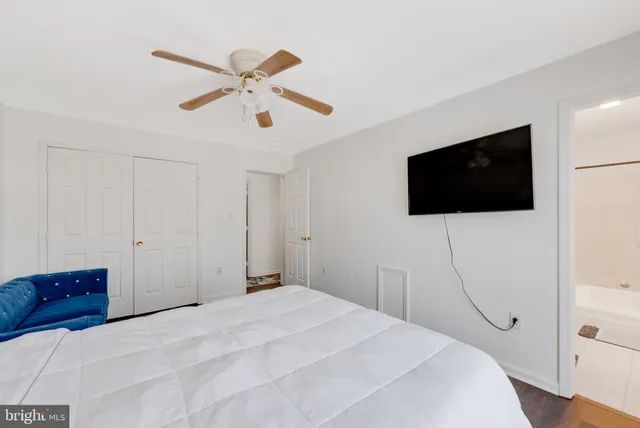 a bedroom with a bed a flat screen tv and a chandelier