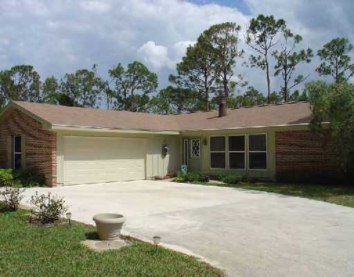 16521 Alexander Run Jupiter, FL 33478 - Photo 1 of 15 a front view of a house with garden
