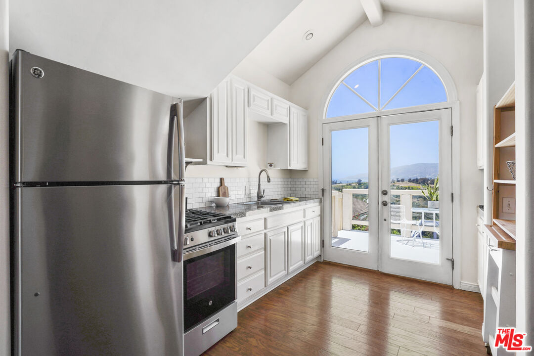 29355 Heathercliff Road, Unit GUESTHOUSE Malibu, CA 90265 - Photo 5 of 26 a kitchen with stainless steel appliances a refrigerator sink and cabinets