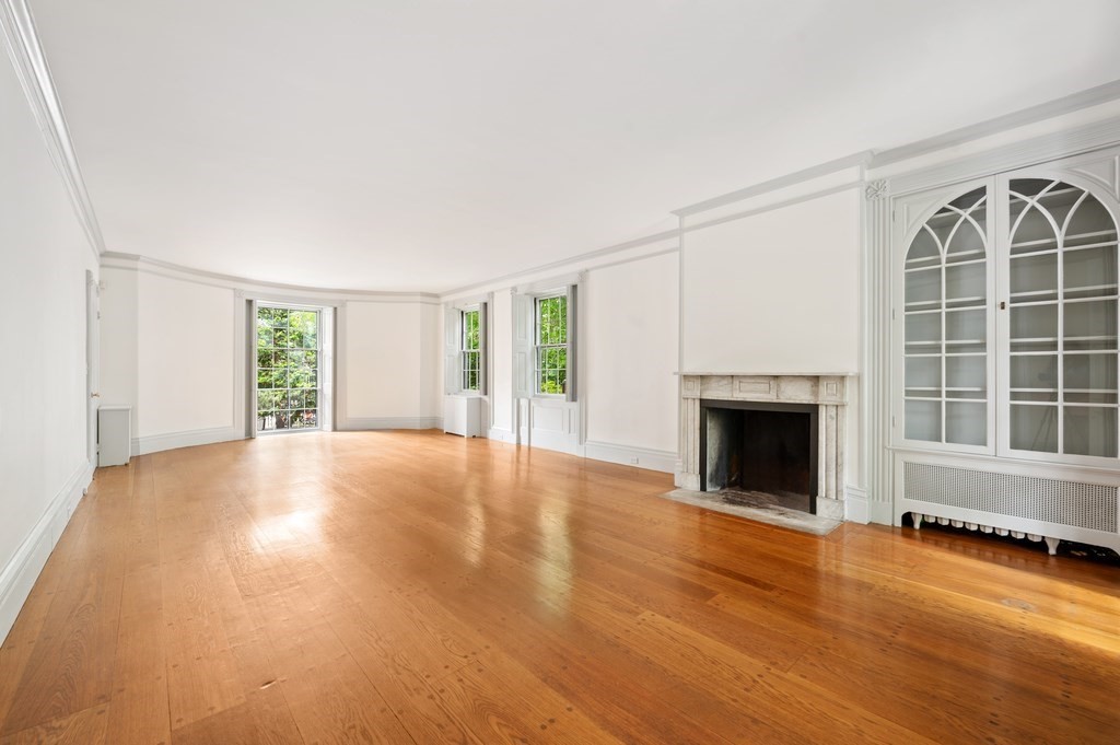 29 Follen Street Cambridge, MA 02138 - Photo 5 of 32 an empty room with windows fireplace and wooden floor