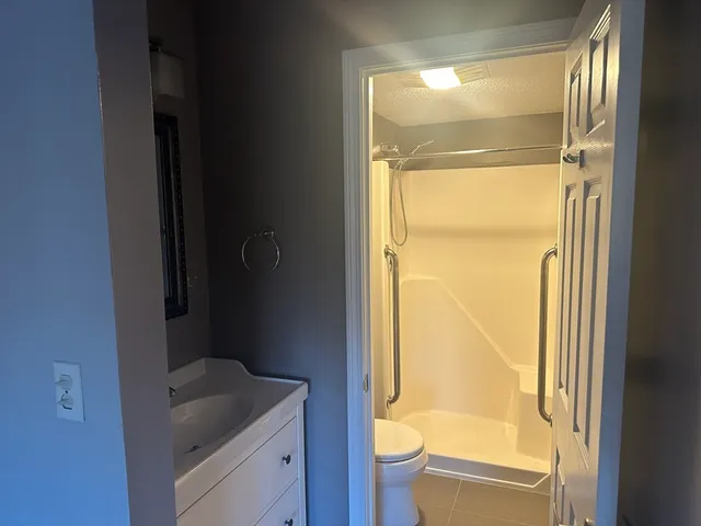 a bathroom with a granite countertop sink toilet and shower