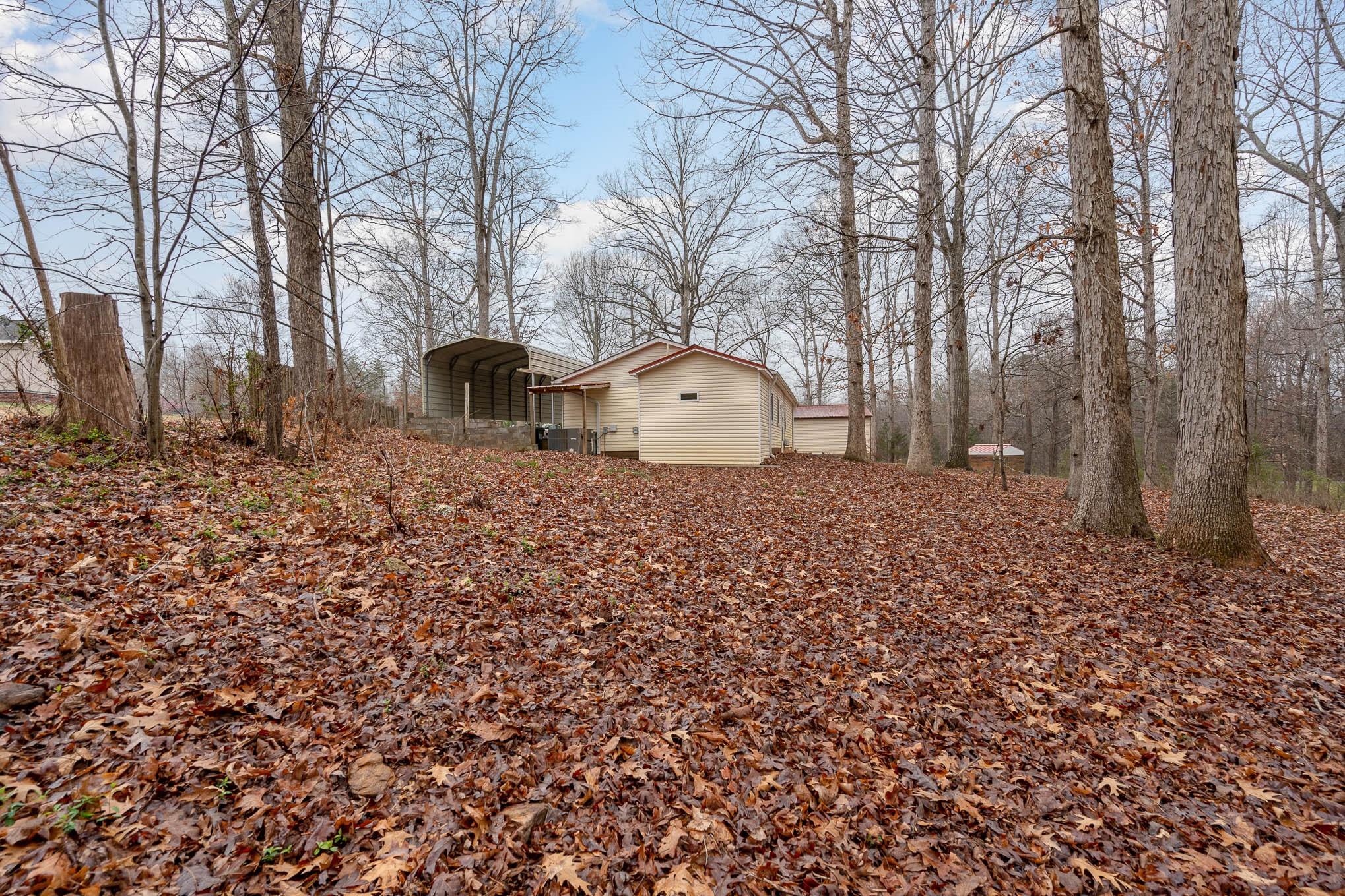 740 Shannon Meadow Road Clover, SC 29710 - Photo 30 of 31 a backyard of a house with large trees and brick walls