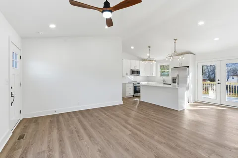 a view of a kitchen with wooden floor and windows