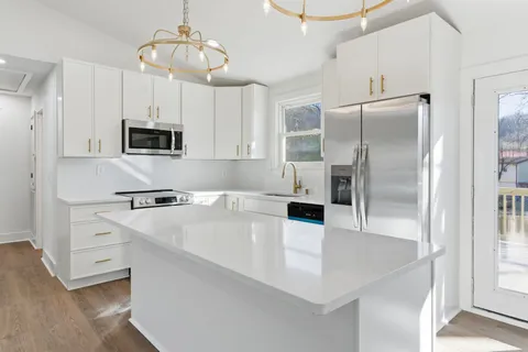 a kitchen with kitchen island a refrigerator stove and microwave